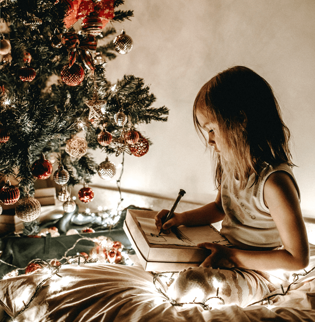 Girl opening christmas present under tree