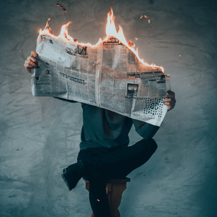 Man reading burning newspaper