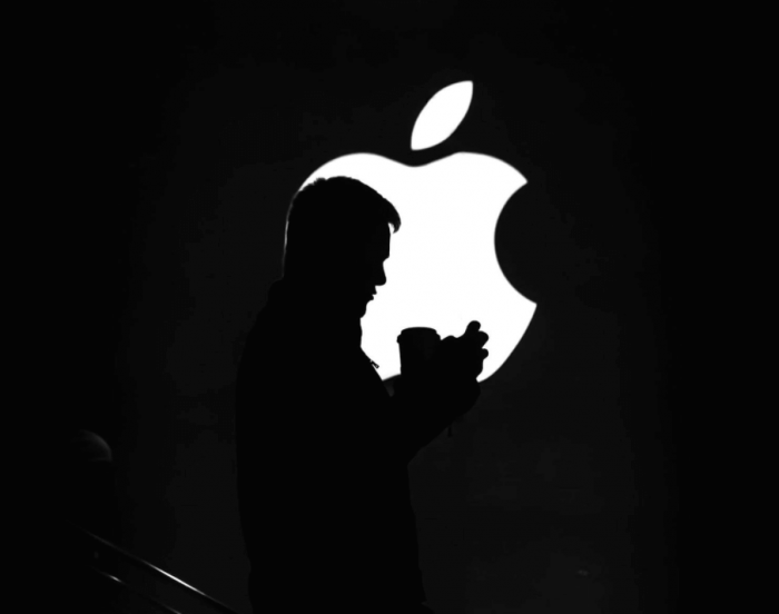 Man standing in front of Apple logo