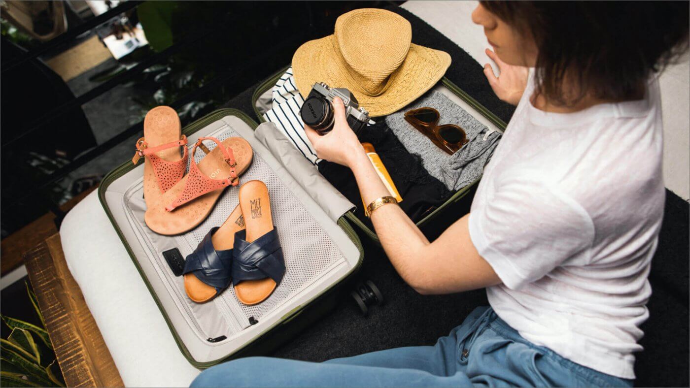 woman packing ketch shoes into a suitcase